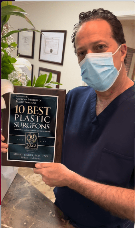 Dr. Linder holding an award for being among the 10 best plastic surgeons. 